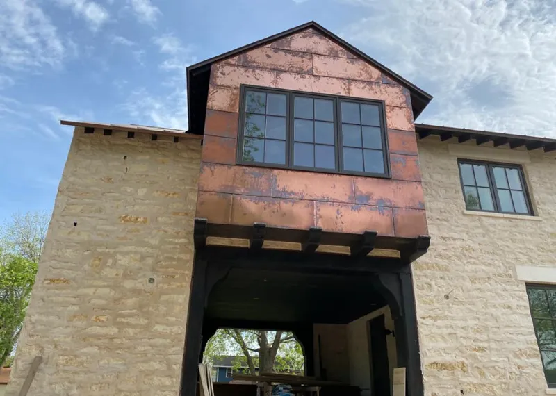 Copper metal panel facade on a stone building for Skylight Installation in Fort Carson